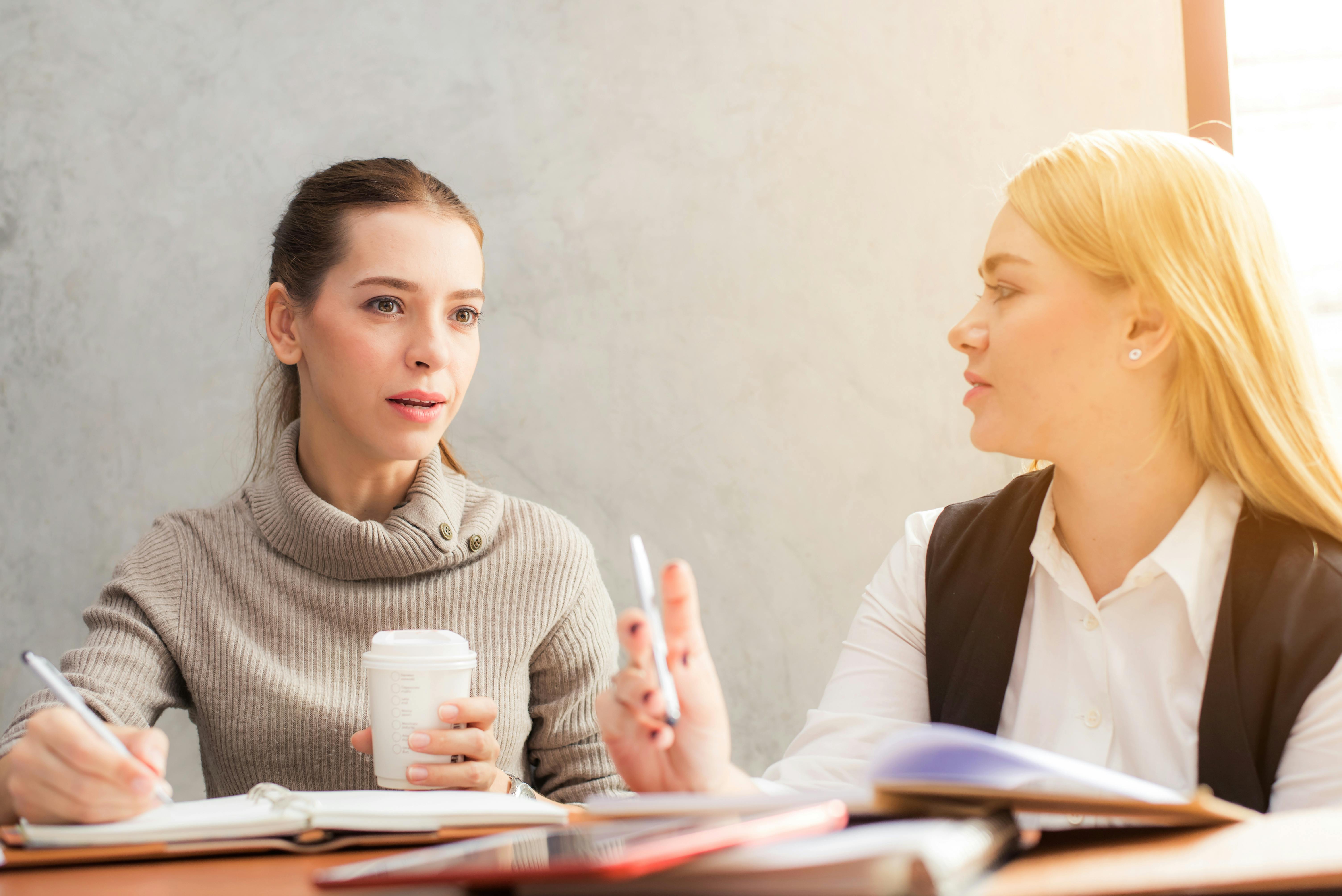 a mentor and a mentee talking at a desk