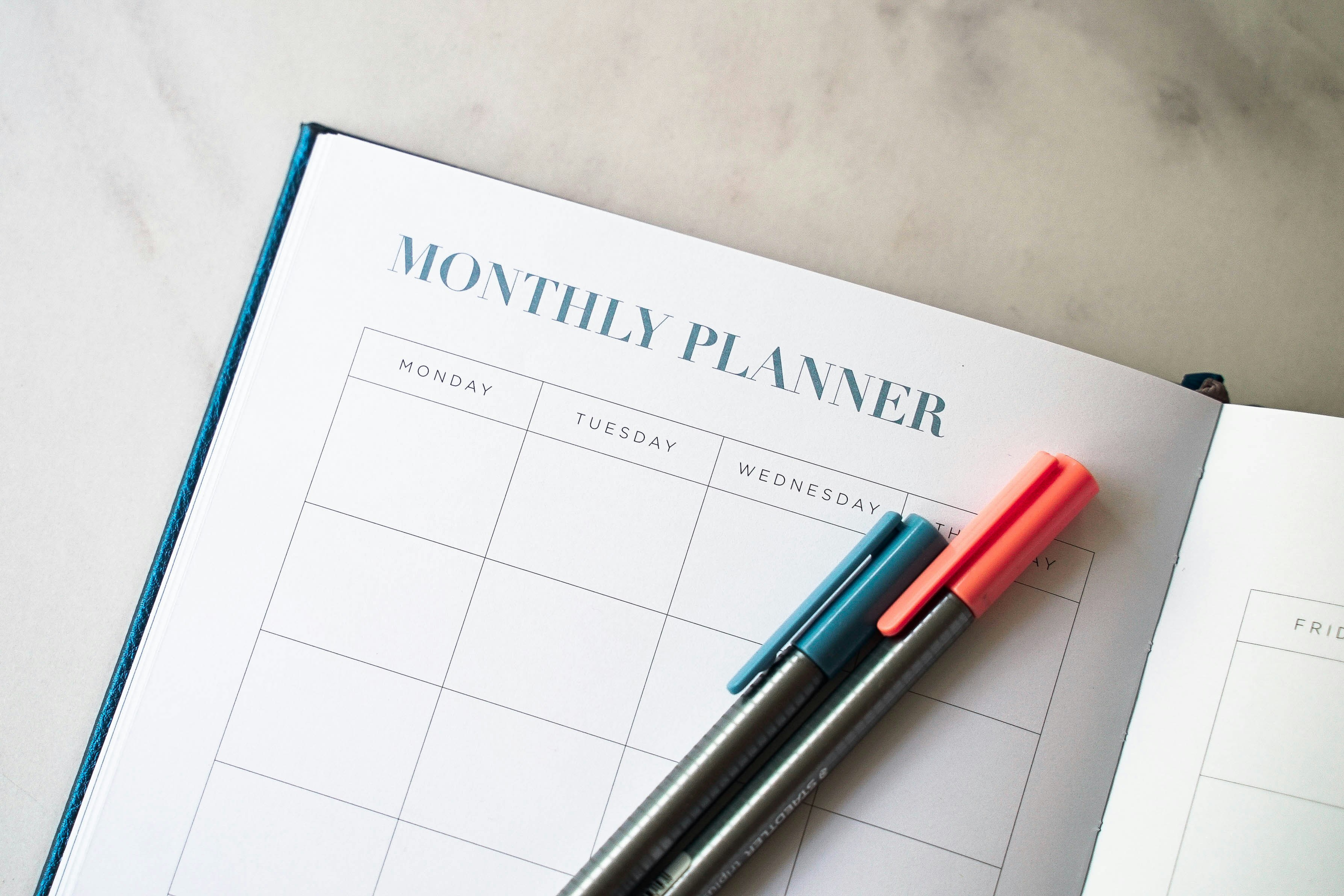 a monthly planner with 2 pens